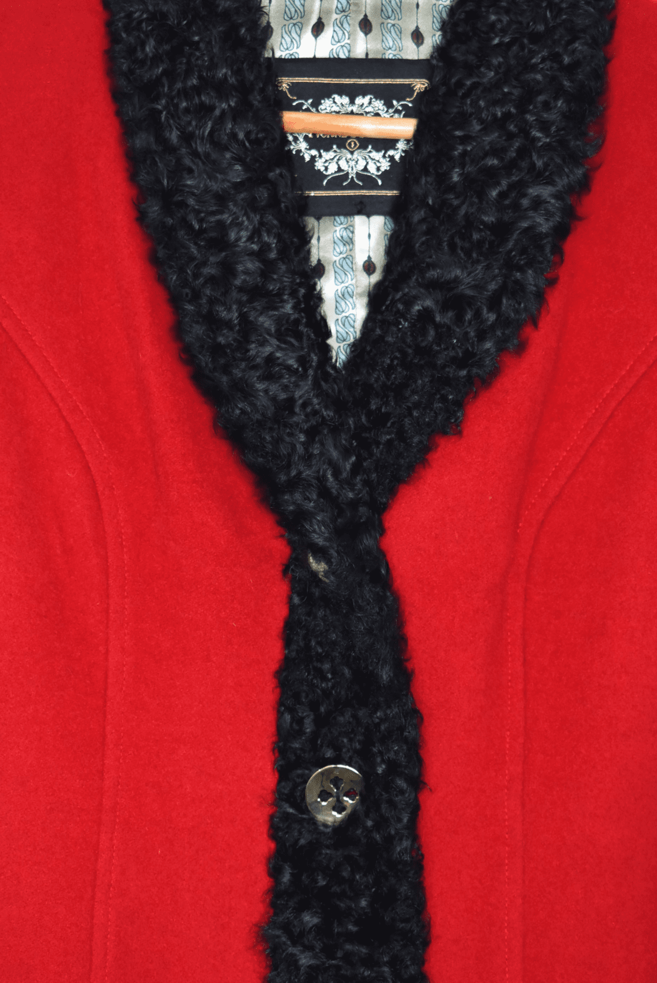 Small, wool, red coat. Cosy wool coat featuring two front patch pockets, gold buttons, and black wool trim around the collar, button wrap and cuffs.