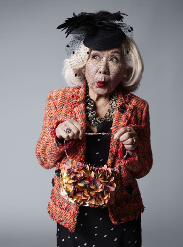 woman posing with fashionable clothes and a fascinator hat