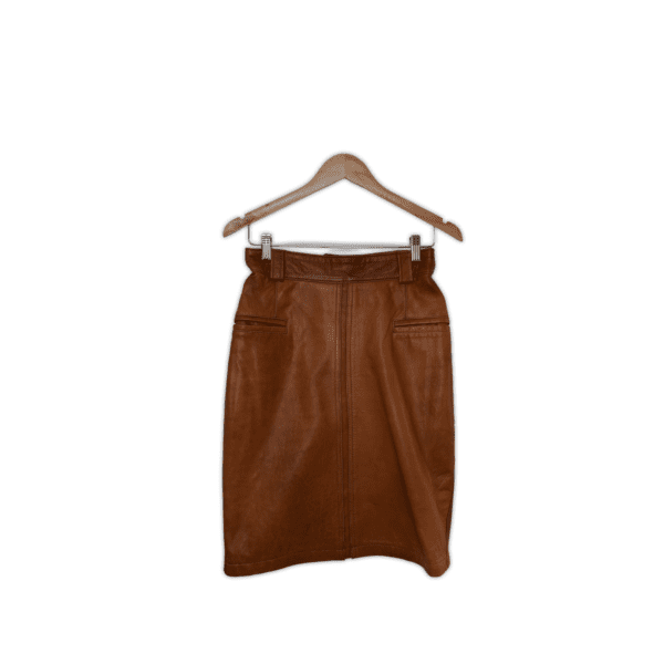 Soft leather pencil skirt, fully lined featuring a zipper center back and dome close waist band, belt loops and two double jetted front pockets. Small, Tan leather.